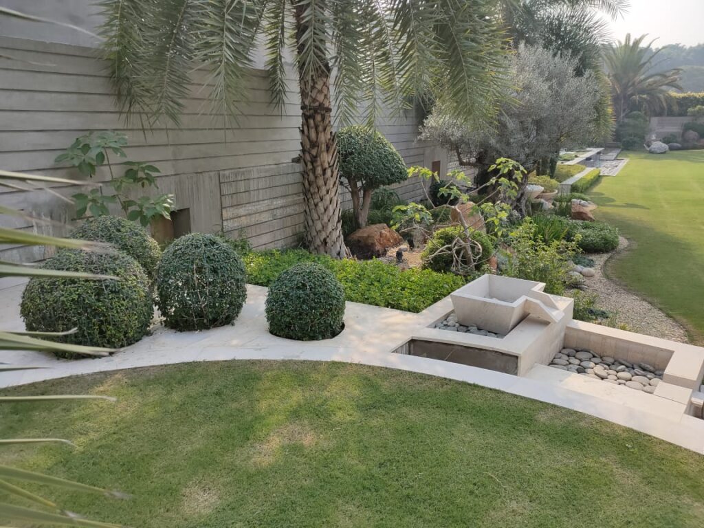 "US Apparel House landscape execution with contemporary green design – LandscapeCompany.pk"
